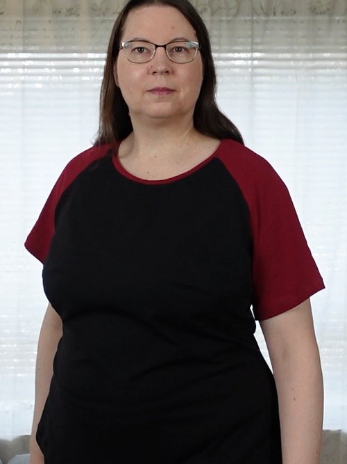 Frau in schwarzem T-Shirt mit roten Raglan-Ärmeln