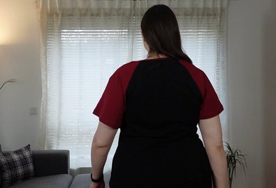 Frau in schwarzem T-Shirt mit roten Raglan-Ärmeln, Rückenansicht